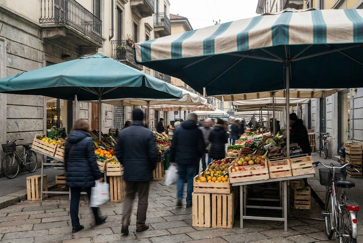 Immagine illustrativa: banchi di mercato rionale con cassette di frutta sotto le tende