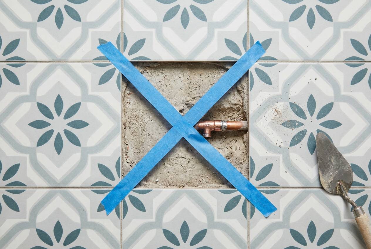 Immagine illustrativa: una sola piastrella rimossa in un bagno, a mostrare il punto esatto della perdita senza demolizioni.